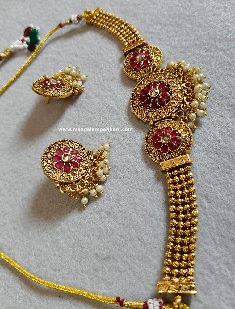 A gold-plated choker necklace set with a floral design and a pair of matching earrings