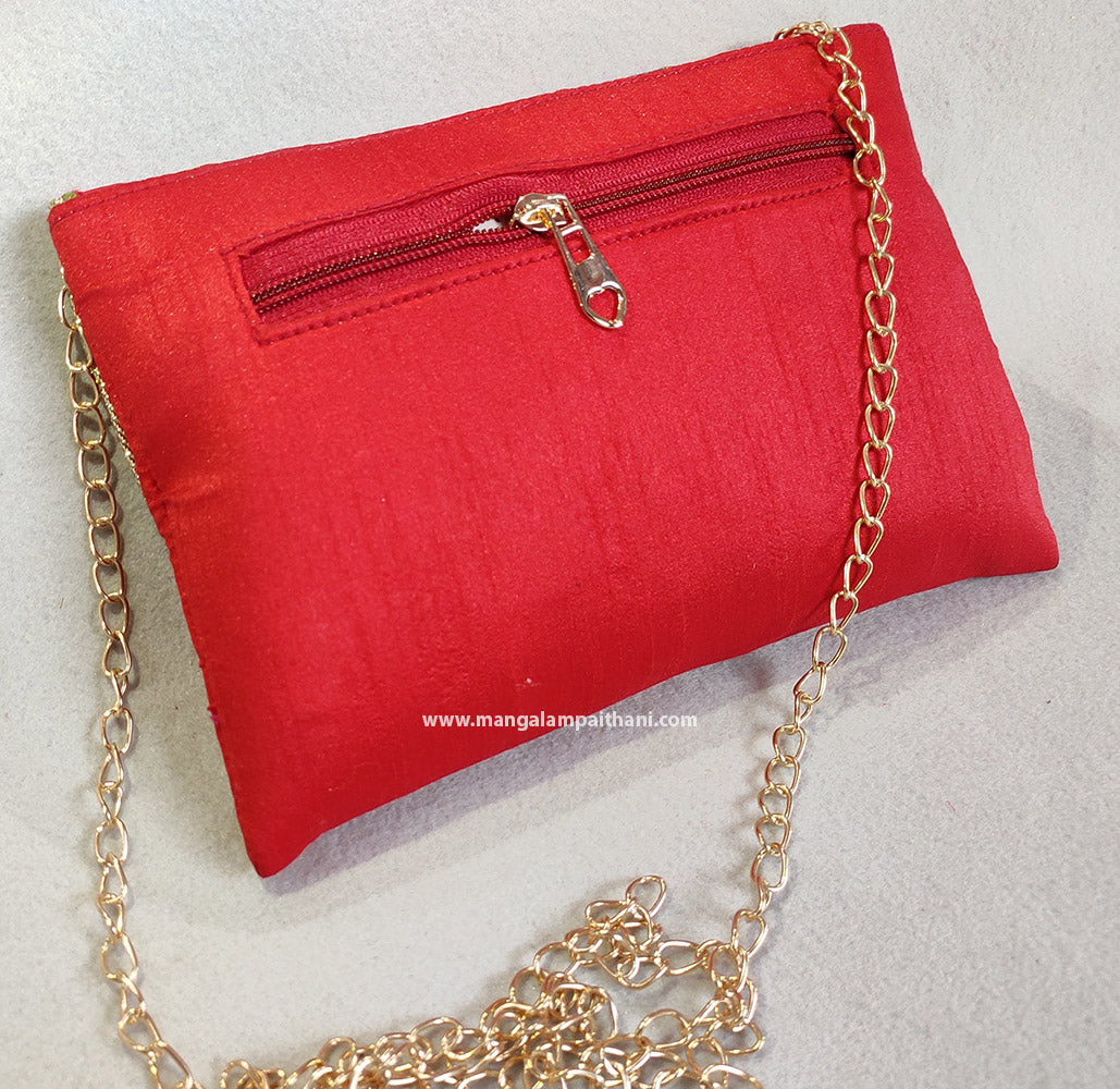 A red and pink floral design clutch purse with a chain strap handle and a push lock closure.