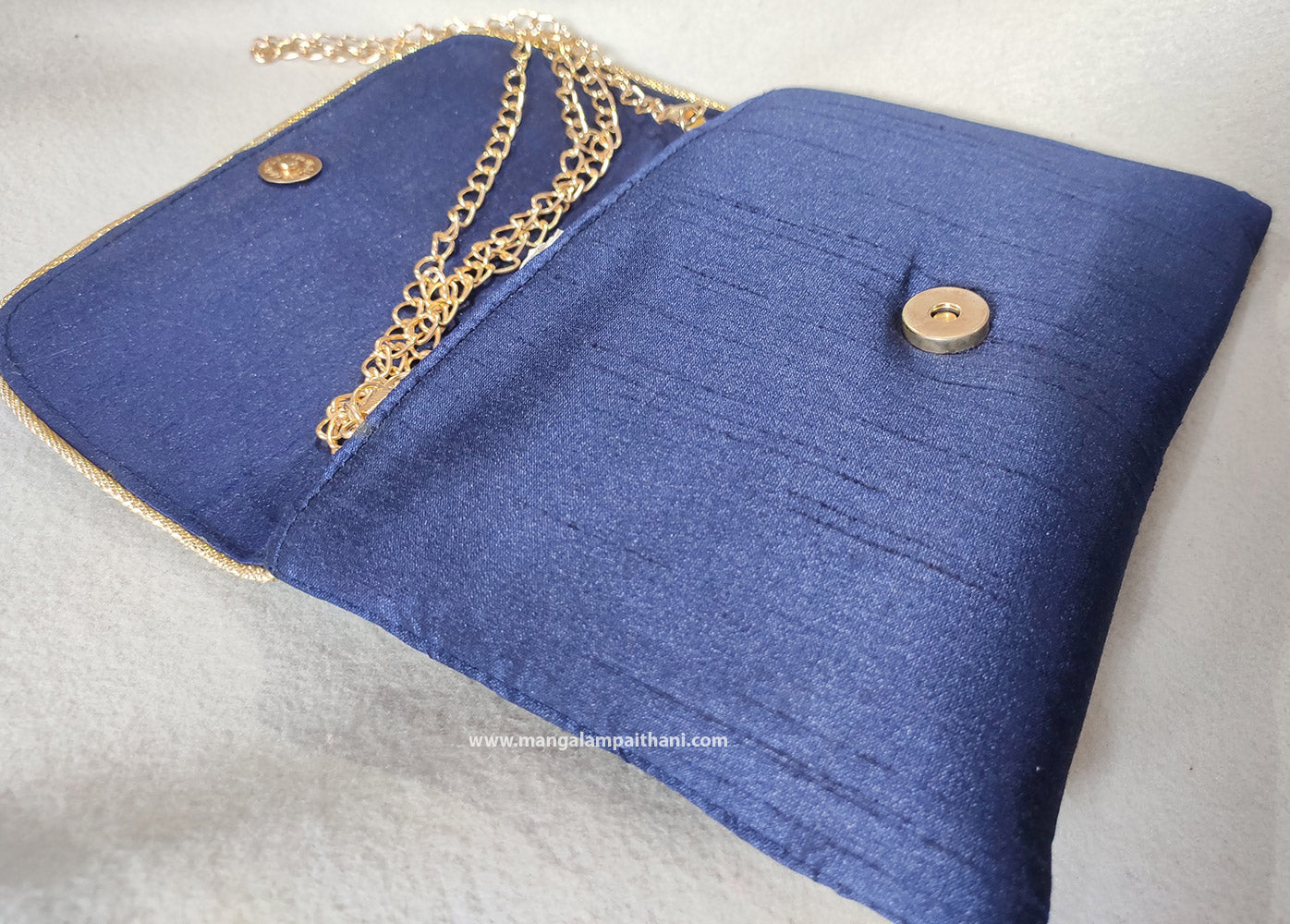 purse with a floral design and a detachable gold chain strap.