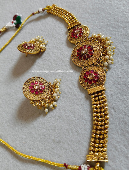 A gold-plated choker necklace set with a floral design and a pair of matching earrings