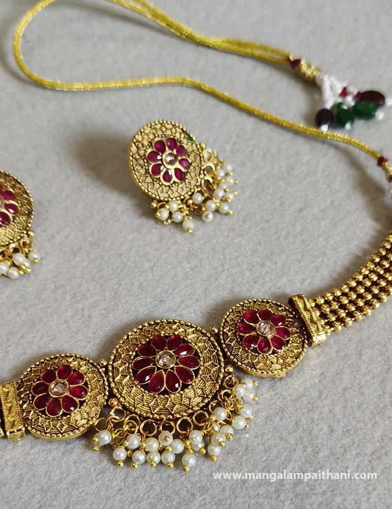 A gold-plated choker necklace set with a floral design and a pair of matching earrings