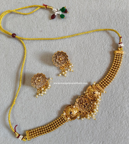 A gold-plated choker necklace set with a floral design and a pair of matching earrings