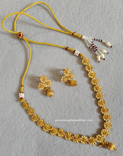 A gold-colored necklace set with a floral design and a pair of earrings