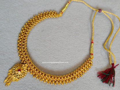 Gold plated choker necklace with a red and yellow design and a tassel at the end