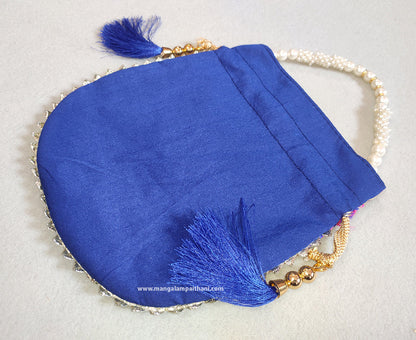 A multicolored designer women's clutch purse with floral patterns and a pearl handle